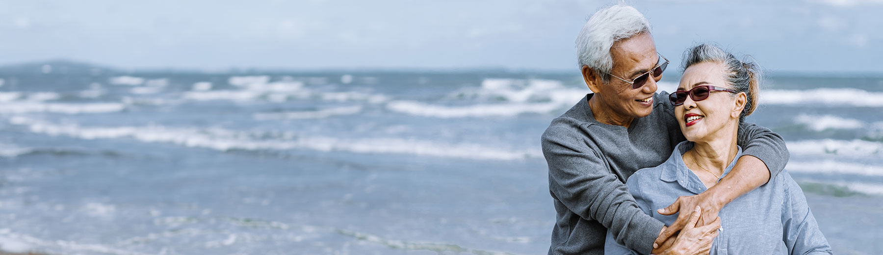 A women and a man smiling in the beach